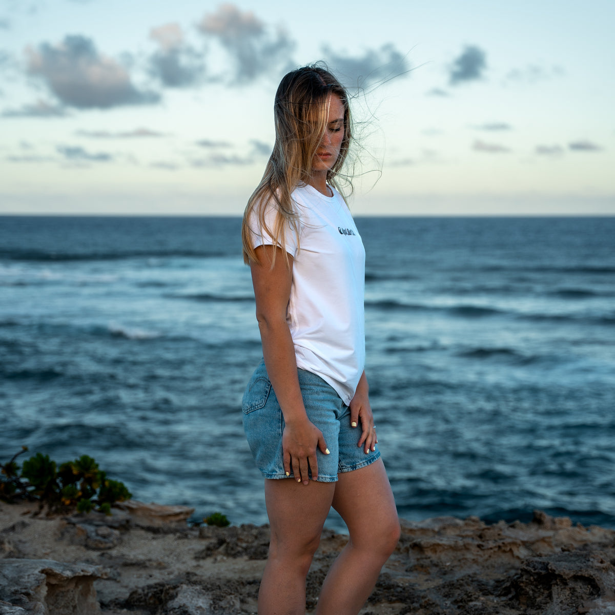 Woman standing on a beach with ocean in the background